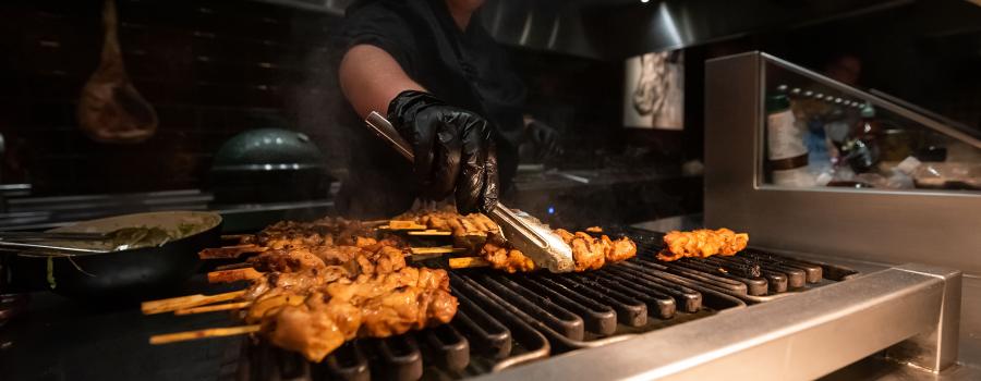 A cook grilling shrimp