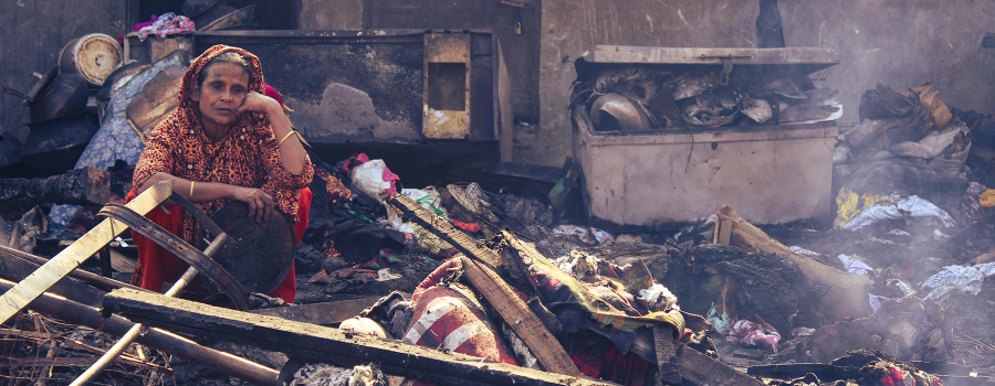 An elderly woman among ruins in Bangladesh